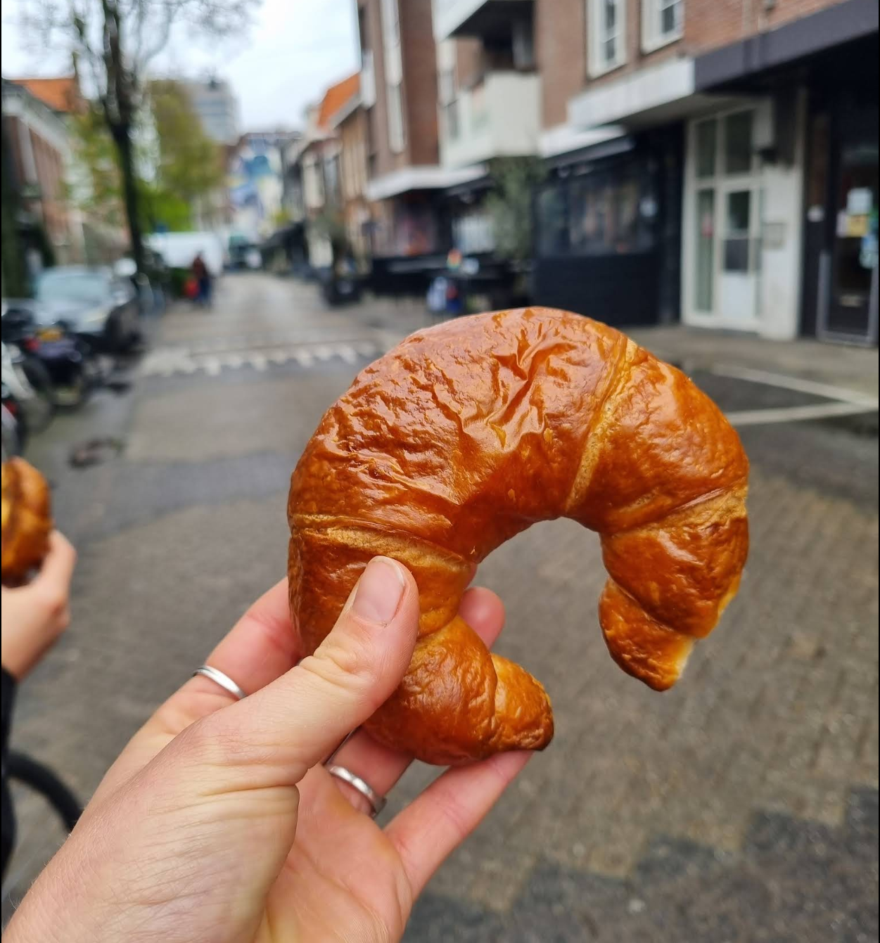 Vers croissant in de hand buiten de bakkerij
